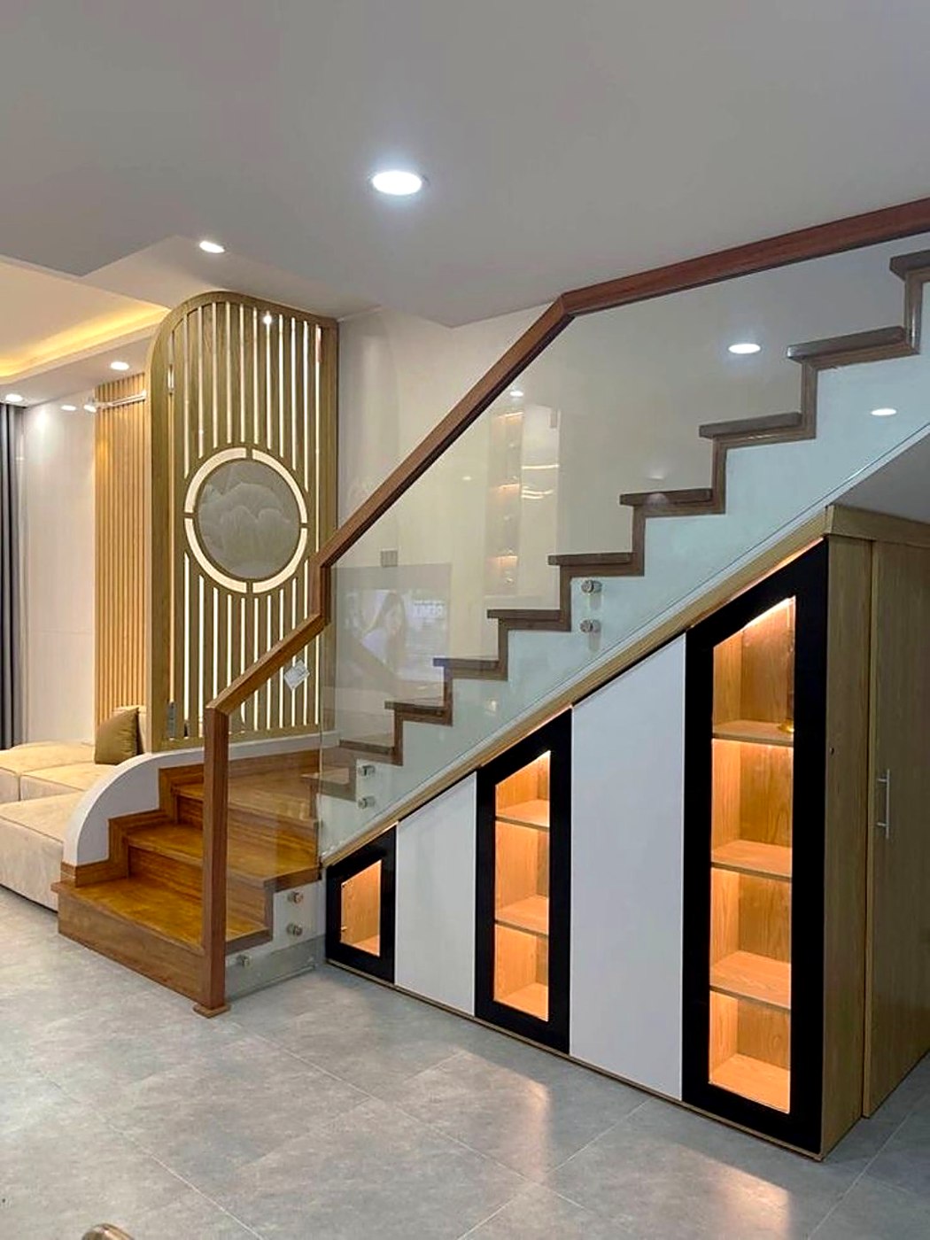 Staircase with glass balustrade and lit display cabinet